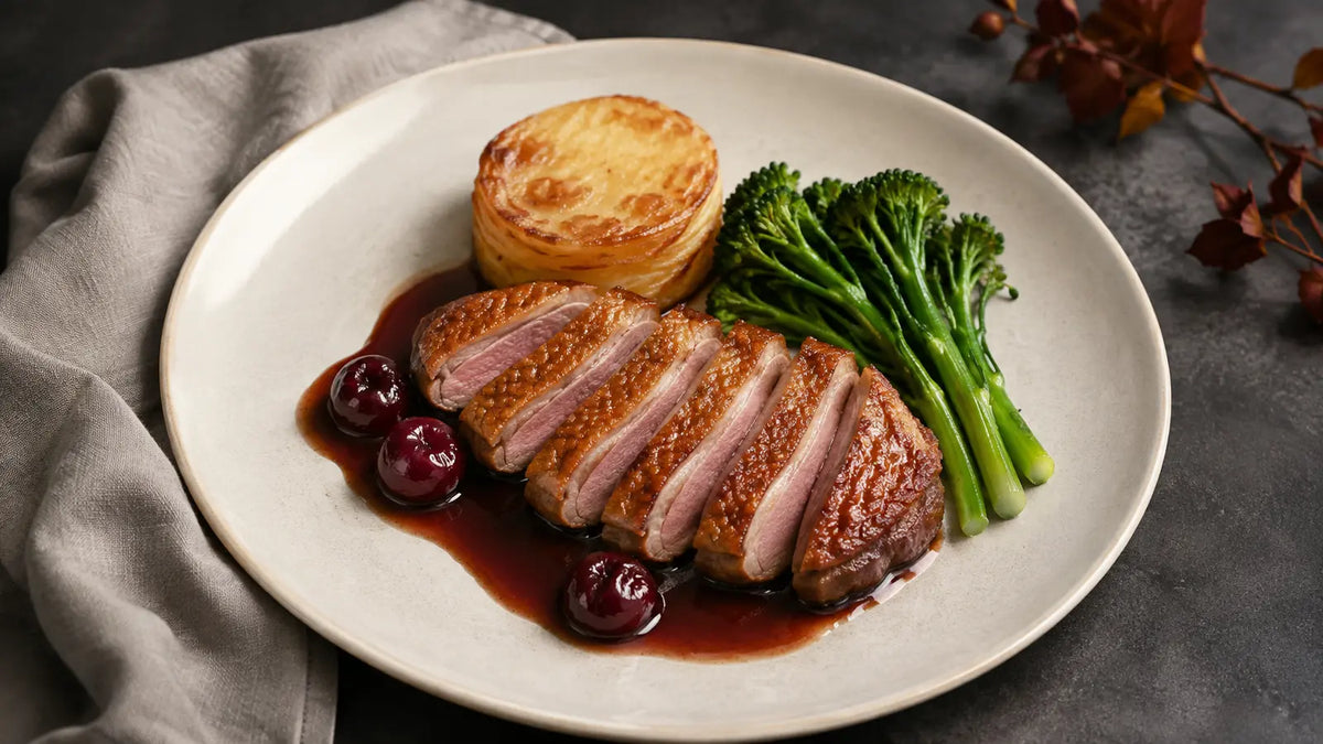 Sliced Game Rub duck breast with cherry pan sauce, fondant potato and tenderstem broccoli.