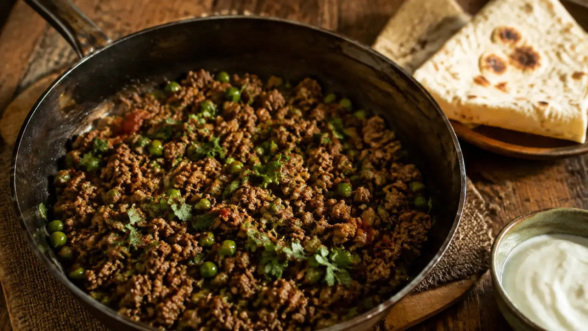 Garam Masala beef keema with peas served in a rustic iron skillet with flatbread and yoghurt.