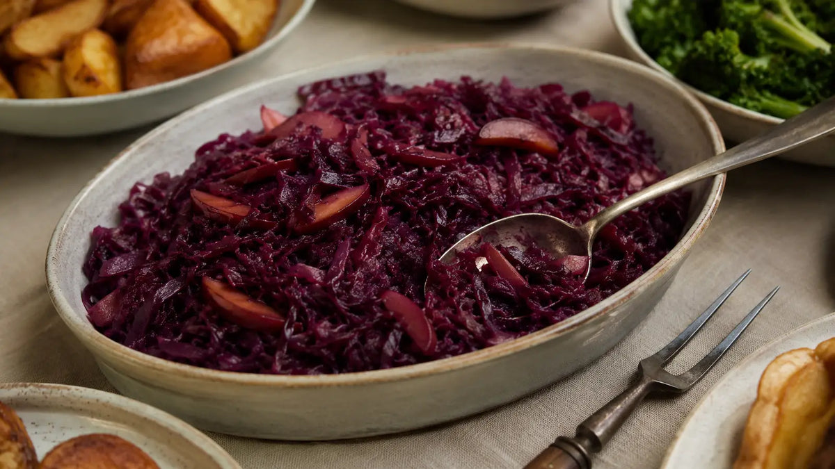 Slow-cooked mulled wine spiced red cabbage with apple served in a large ceramic dish for a winter roast dinner.