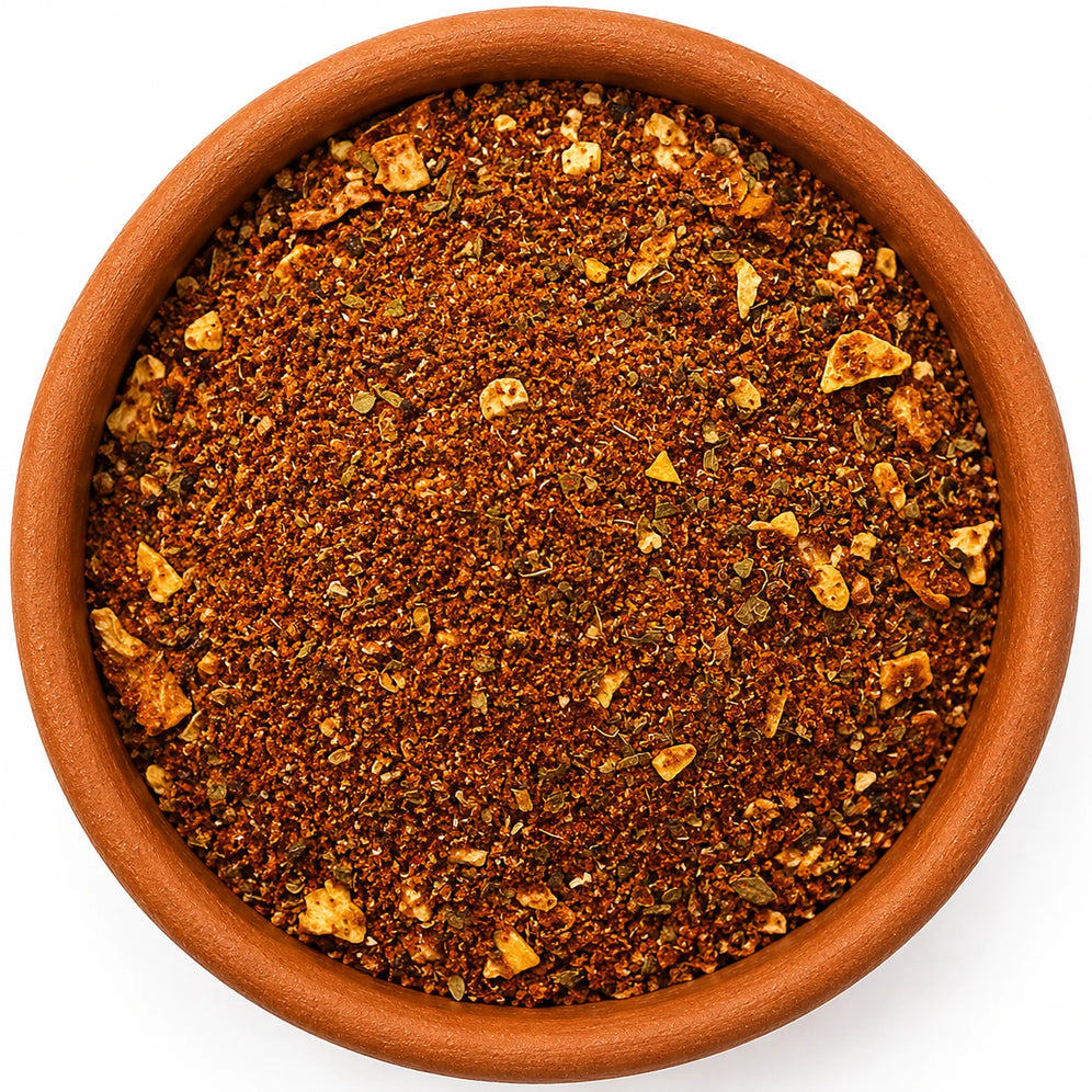 Harissa Moroccan Spice Blend in a rustic terracotta bowl, photographed from directly above on a clean white background, handcrafted by Spice & Dipity.